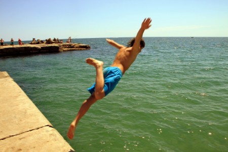 Man-Jumping-in-the-black-sea-water__53014-600x400